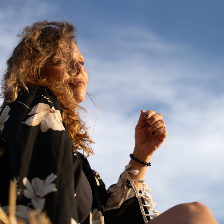 Chica sobre bala de paja al atardecer