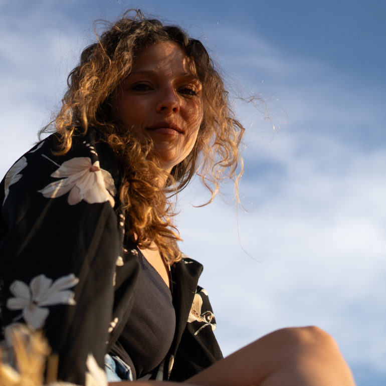 Chica posando al atardecer contrapicado